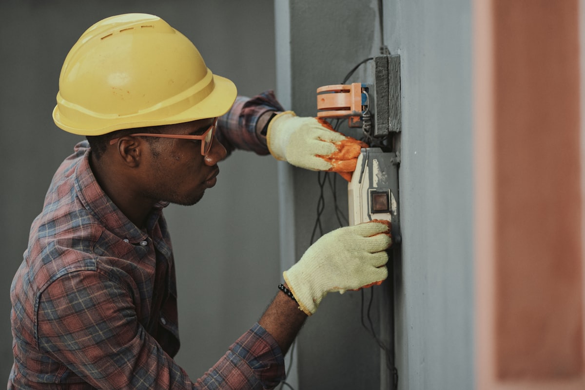Licensed electrician testing an electrical panel with a multimeter